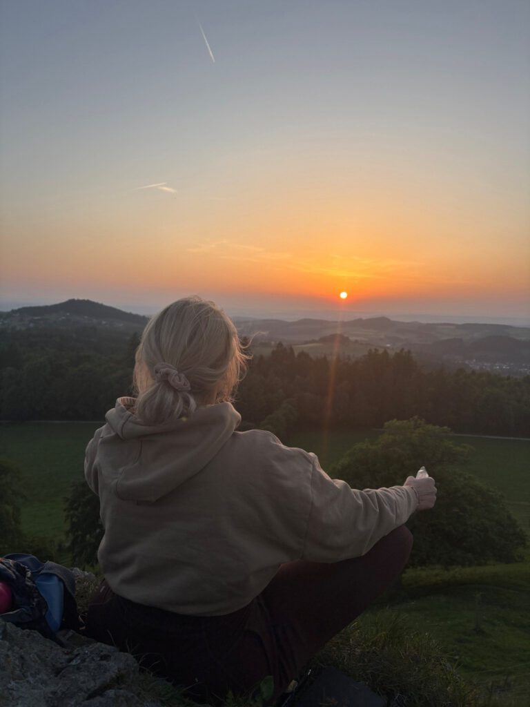 Frau auf Berg im Sonnenuntergang